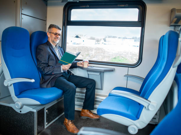 istock Businessman reading book and traveling by train 1364185765