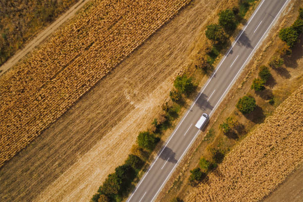 istock Minivan driving down the road through countryside landscape in summer afternoon 1364186211
