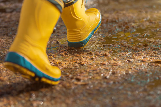 istock Child with rubber rain boots walking on wet sidewalk in autumn afternoon 1364186298