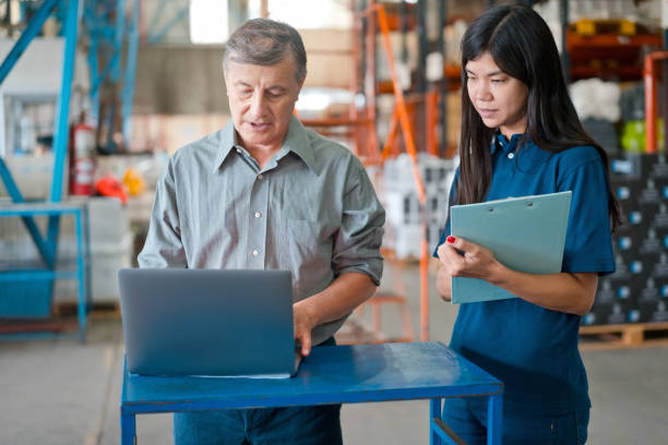 male warehouse manager talking with employee - polo shirt two people men working imagens e fotografias de stock