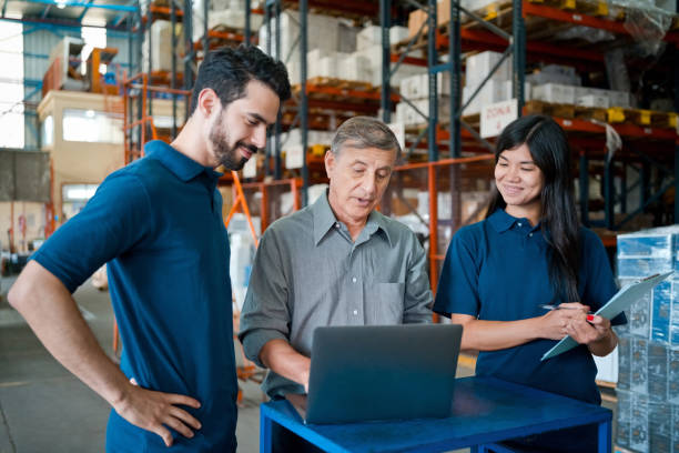 istock Male warehouse manager talking with employees 1364188539