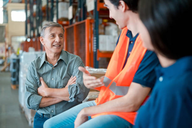 gerente y empleados en almacén - manager foreman warehouse arms crossed fotografías e imágenes de stock