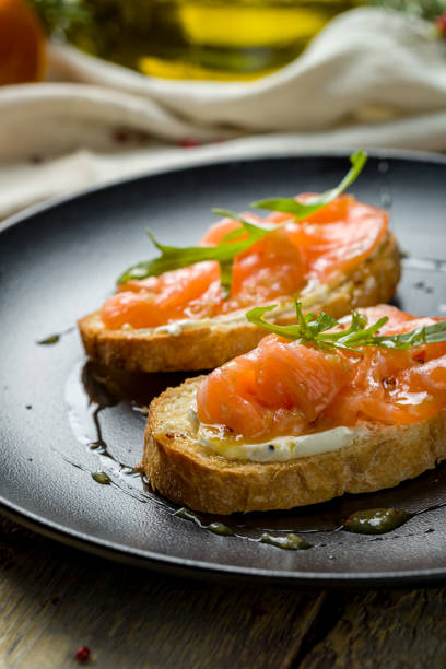 istock Bruschetta with salmon and cheese on black plate macro close up 1364189739
