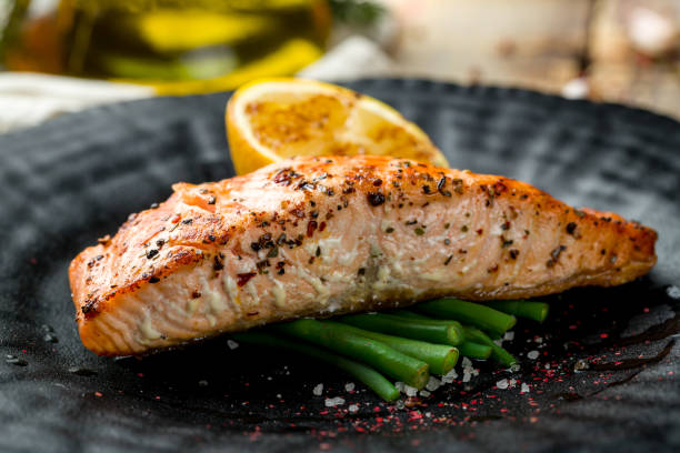 istock Salmon steak on the grill on black plate macro close up 1364190154