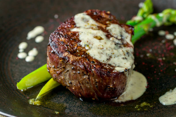 istock roast beef Steak with asparagus on black plate on wooden table macro close up 1364190182