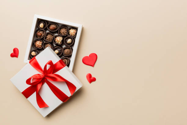 delicious chocolate pralines in red box for valentine's day. heart shaped box of chocolates top view with copy space - chocolate candy gift package chocolate imagens e fotografias de stock