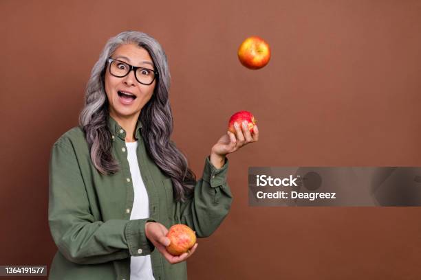 Photo Of Impressed Old Grey Hairdo Lady Juggle Wear Shirt Eyesight Isolated On Brown Color Background Stock Photo - Download Image Now