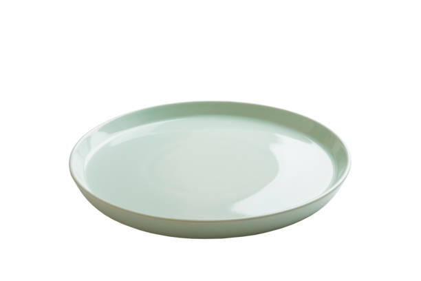 istock Blue ceramic round plate isolated over white background. perspective view 1364191592