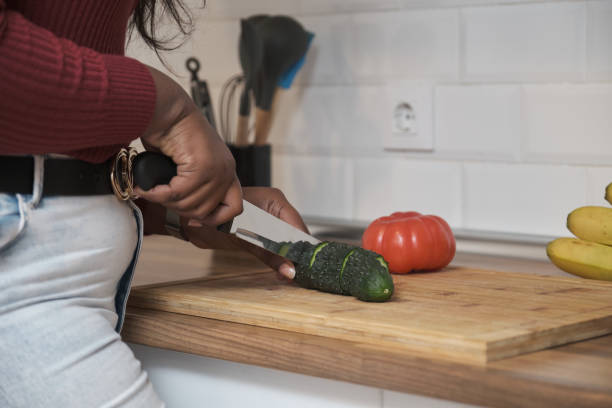 istock Unrecognizable cuban woman smiling and cutting vegetables in the kitchen. 1364192595