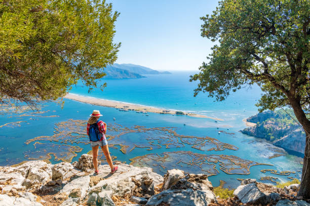 istock Hiker woman looking down at the beach. 1364194888
