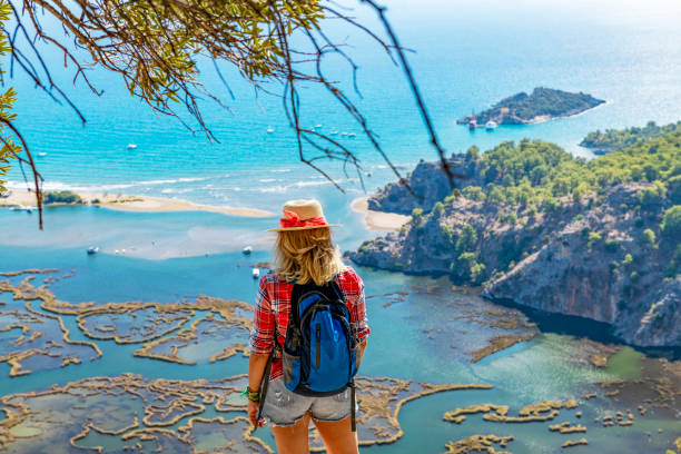istock Hiker woman looking down at the beach. 1364196302