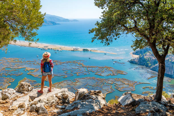 istock Hiker woman looking down at the beach. 1364196466