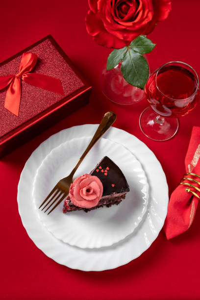 istock Valentines day dinner with table place setting with red gift, red roses,  with chocolate cake. View from above.Valentines day dinner concept 1364199938