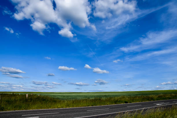 estrada e céu azul com nuvens rua sem carros - tranquil scene sky street road - fotografias e filmes do acervo