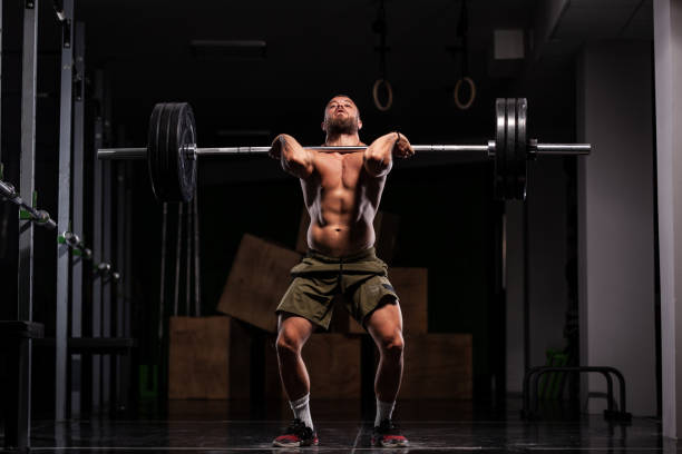 istock Muscular athlete lifting very heavy barbell 1364201737