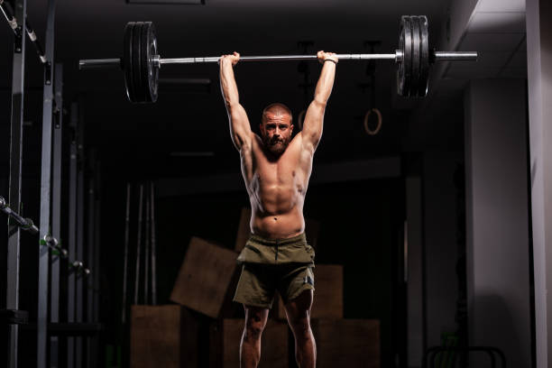 istock Muscular athlete lifting very heavy barbell 1364201738
