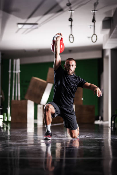 istock Muscular athlete power lifting a kettlebell. Man working out indoors 1364202151