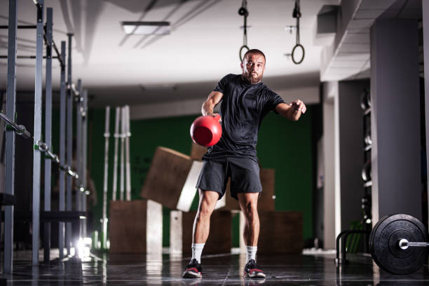 istock Muscular athlete power lifting a kettlebell. Man working out indoors 1364202155
