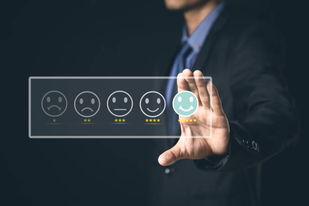 istock Customer Service and Satisfaction Concept Businessmen touch the virtual screen on happy smiley icons to achieve service satisfaction and feedback with excellent rated reviews. 1364202661