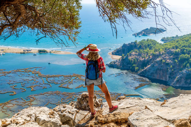 istock Hiker woman looking down at the beach. 1364208359
