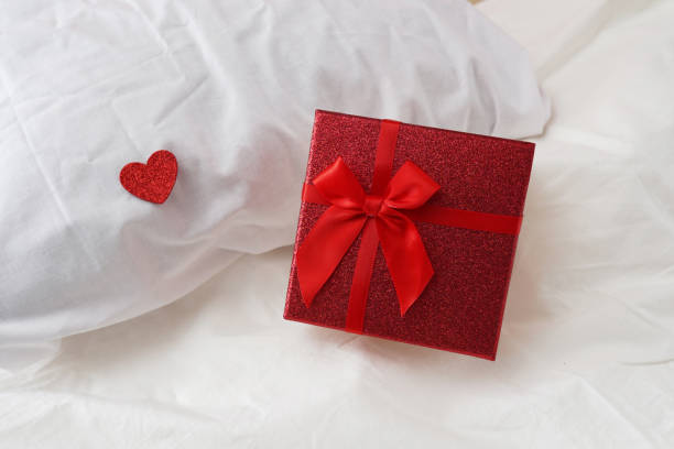 istock Gift box with a bow and red heart on the bed. Valentine's day gift 1364208492