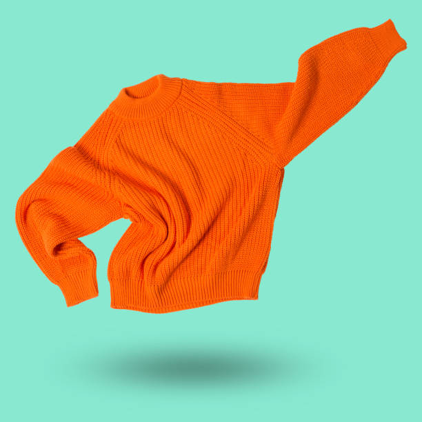 istock orange wool knitted sweater flies like a super hero, hand up, levitates, concept 1364208687