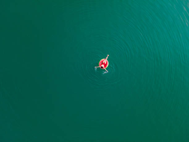 junge glückliche frau, die in blauem azurblauem wasser auf aufblasbarem ringkreis schwimmt - swim ring stock-fotos und bilder