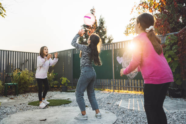istock Three girls playing with ball on the playground 1364209918