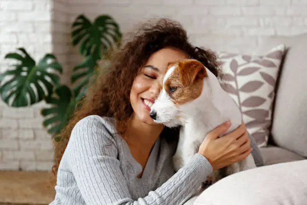 Photo of Young woman with her dog chilling at home.