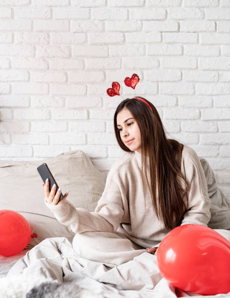 istock Woman celebrating sitting on the bed making up 1364212684