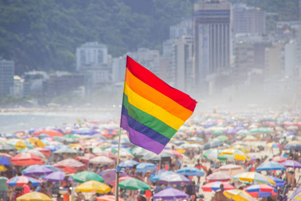 rainbow flag of the LGBT movement at Ipanema beach in Rio de Janeiro - Brazil. stock photo