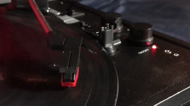 record player with needle on spinning vinyl with controls