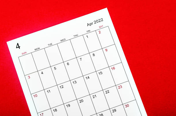 istock April 2022 calendar sheet on red background. 1364216530
