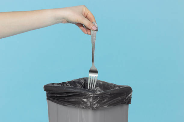 istock throw fork in trash can, fork in hand in front of trash can, diet concept 1364216628