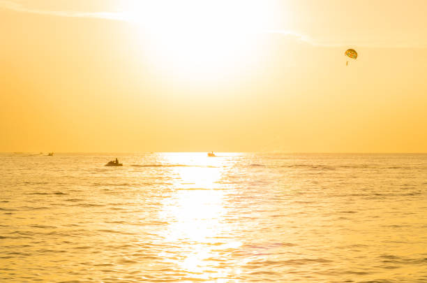 Tourists parasailing in sunset time at Phuket Beach, Thailand