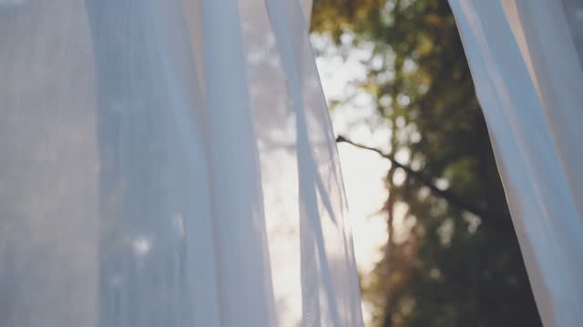 white transparent curtain fabric in wind blowing with sunshine