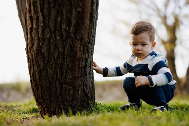 istock Cute little boy picking daisies on spring meadow 1364223759