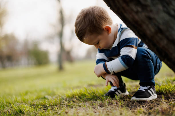 istock Cute little boy picking daisies on spring meadow 1364224488