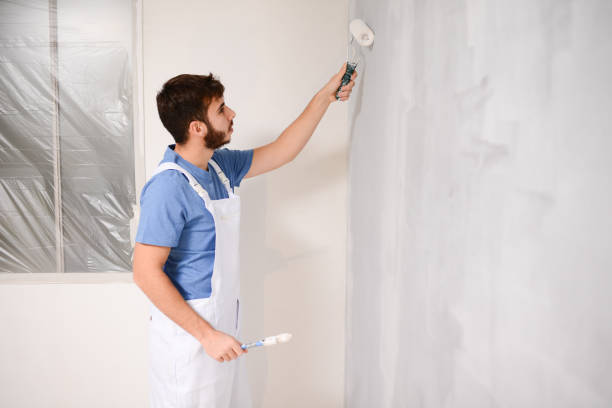 istock handsome young man professional painter in construction site wall painting renovation in a client house 1364226997