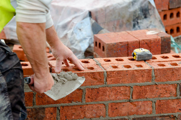 Bricklayer laying bricks on mortar on new residential house construction Bricklayer laying bricks on mortar on new residential house construction bricklayer stock pictures, royalty-free photos & images