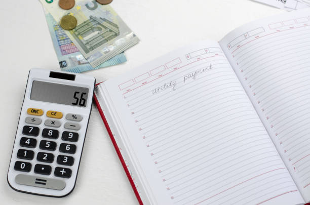 istock Blank notepad with the inscription Pay utility bills, calculator and money on the table. Monthly utility bills 1364229595