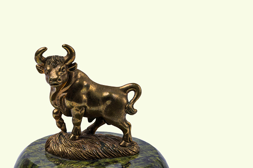 Beautiful view of bronze figure of Taurus cattle sign isolated on yellow  background.