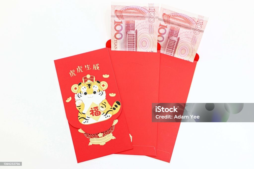 Chinese New Year lucky money red envelopes with 100 Yuan notes inside, one envelope has special tiger year design, the Chinese greeting text translates as blessing with vigour of a tiger Abundance Stock Photo