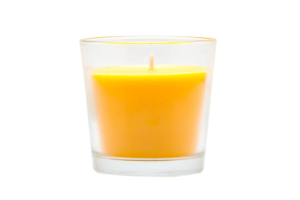 Yellow candle in a glass on a white background