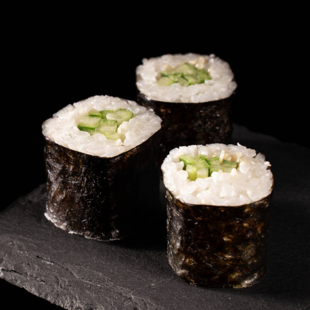 japanese sushi rolls with cucumber and rice japanese sushi rolls with cucumber and rice on a black background Sushi menu. Japanese cuisine. maki sushi stock pictures, royalty-free photos & images