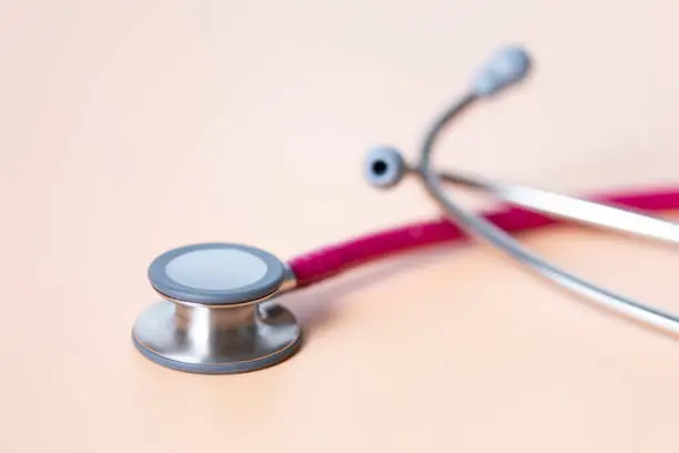 Photo of Modern Stethoscope on a light orange background.