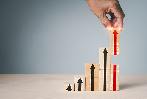 Hand stacking wood blocks on a table with the symbol Action plan, Goal and target, success and business target idea, project management, and corporate strategy development