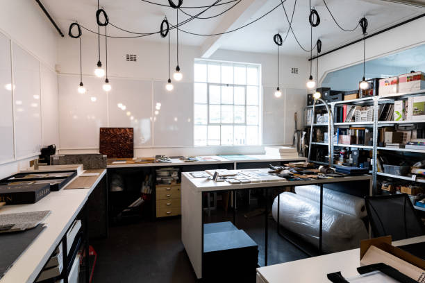 Illuminated bulbs hanging from ceiling in empty modern office with furniture and supplies
