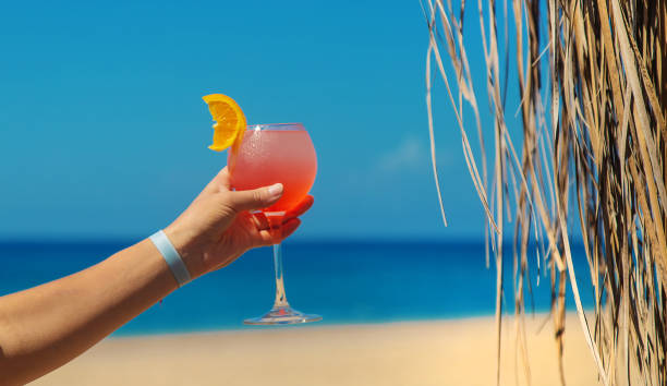 istock Woman on the beach holding a cocktail in her hands. Selective focus. 1364241725