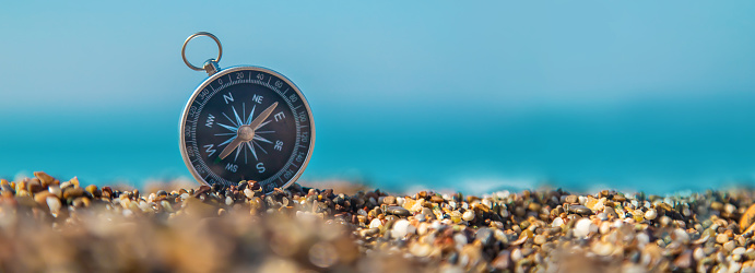 Compass on the sea beach. Selective focus. Travel.